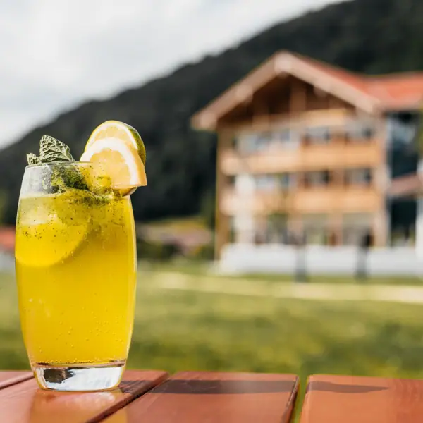 Limonade in einem Glas und mit dem aja Ruhpolding im Hintergrund.