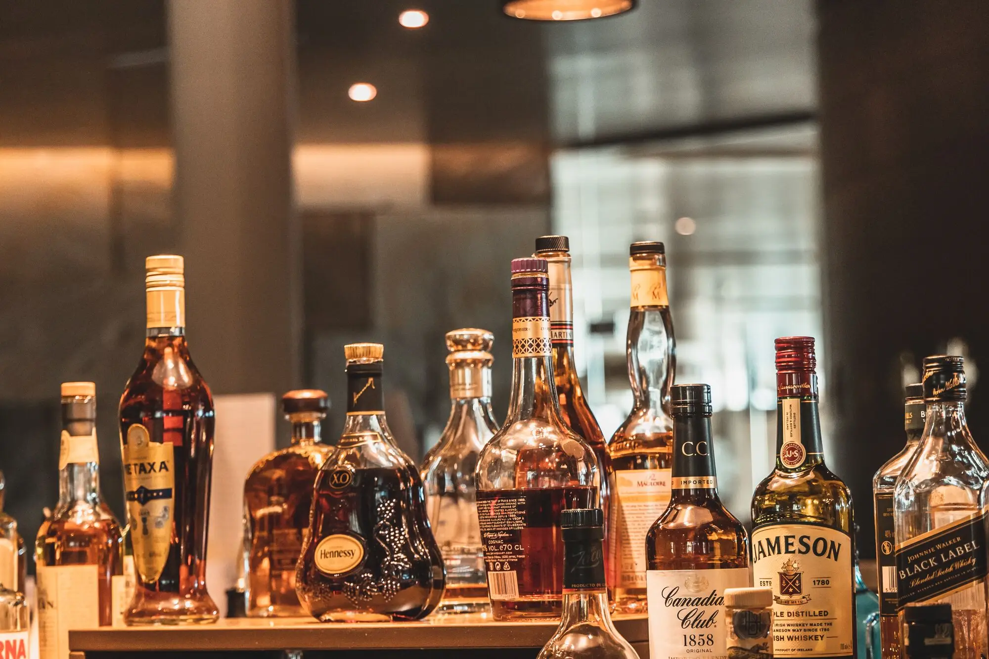 A selection of alcohol bottles on a counter, including whisky and liqueurs.