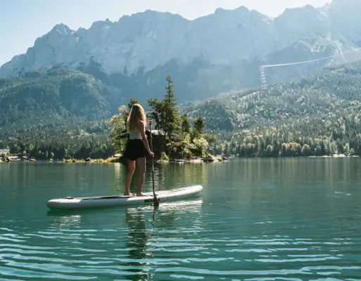 Eine Frau auf einem Paddleboard auf einem See.