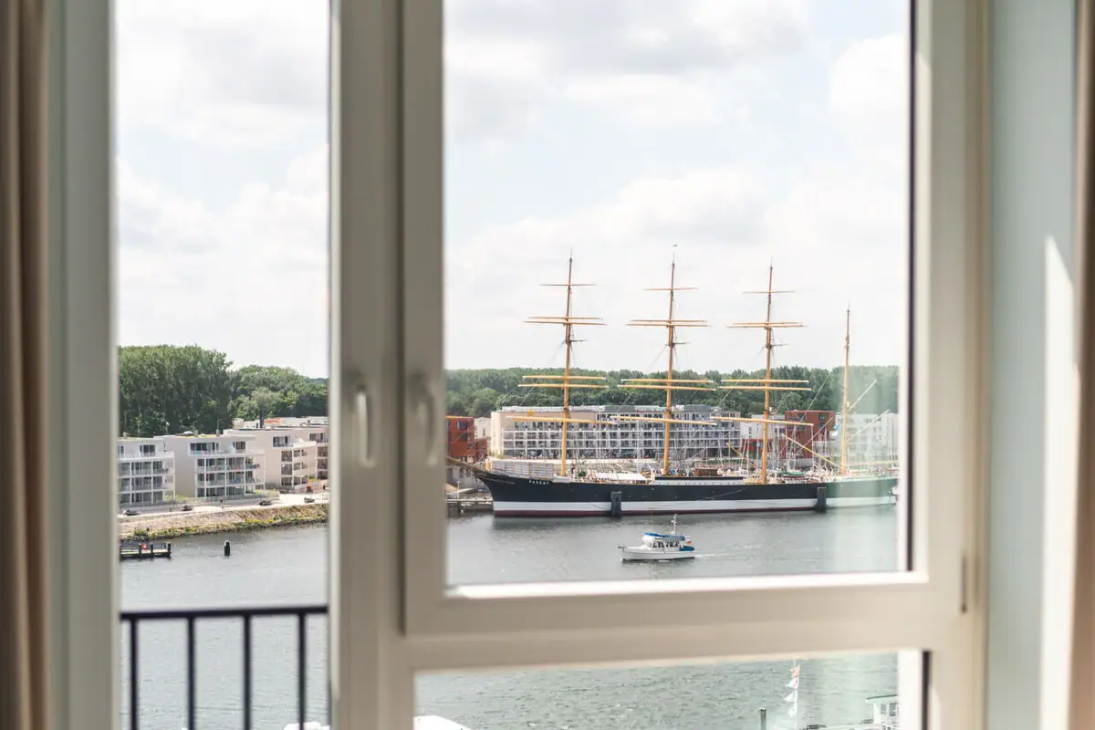 Blick aus einem Fenster auf ein Schiff und einen Hafen.