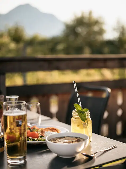 Snacks und Getränke im Biergarten Ein Tisch mit Essen und Getränken darauf.