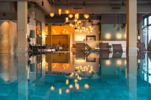 Innenpool Ein moderner Innenpool Bereich mit Liegen und Lampen im Hintergrund.