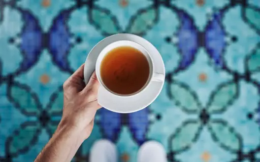 A hand holding a cup of tea.