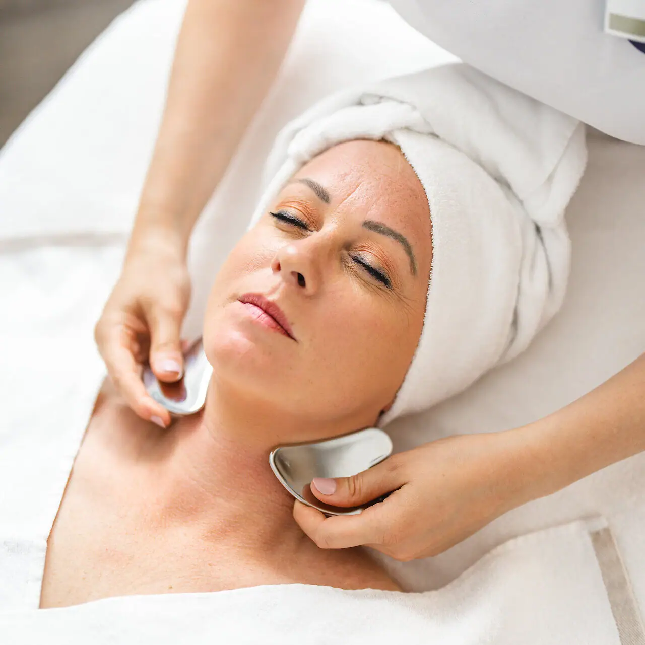 SPA-Anwendung Eine Frau erhält eine Gesichtsmassage.