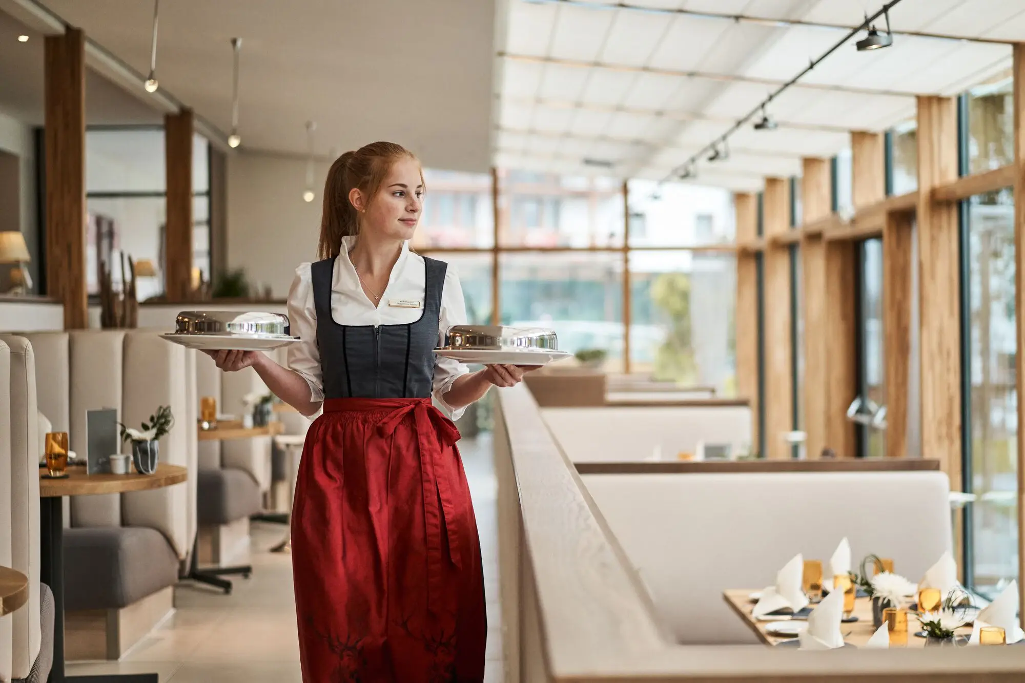 Frau hält zwei Teller in einem Restaurant.