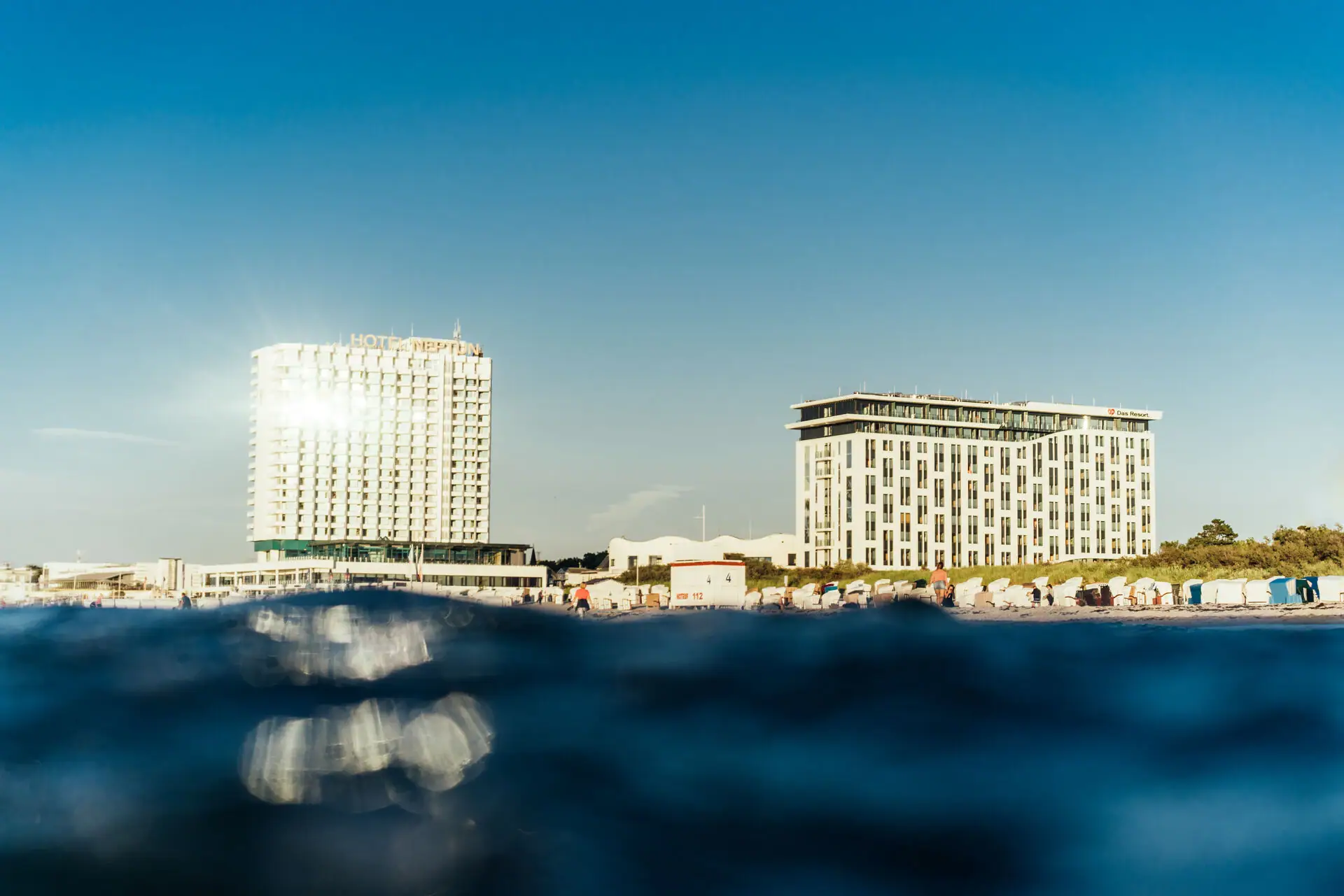 Ein Gewässer mit dem aja Warnemünde im Hintergrund.