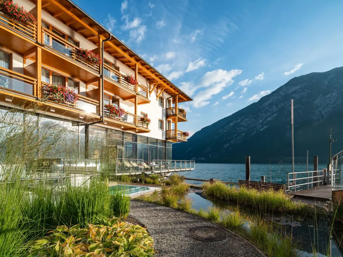 Fürstenhaus am Achensee Ein Gebäude mit einem See und Bergen im Hintergrund.
