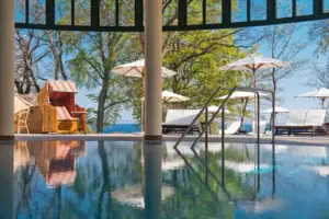 Ein Pool mit einem Liegestuhl und Sonnenschirmen.