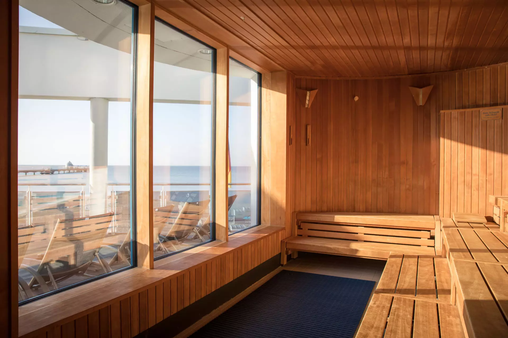 Saunaraum mit Holzwänden und Fenstern mit Blick auf den Strand