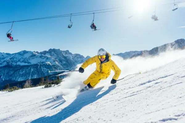 Eine Person fährt auf Skiern einen schneebedeckten Berg hinunter.