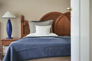 Senior-Suite  Ein Bett mit einer blauen Decke und einem weißen Kissen.