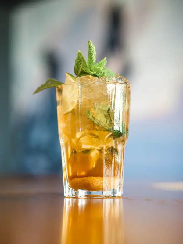 Drink im aja Warnemünde Ein Glas mit einem Cocktail und Minzblättern.
