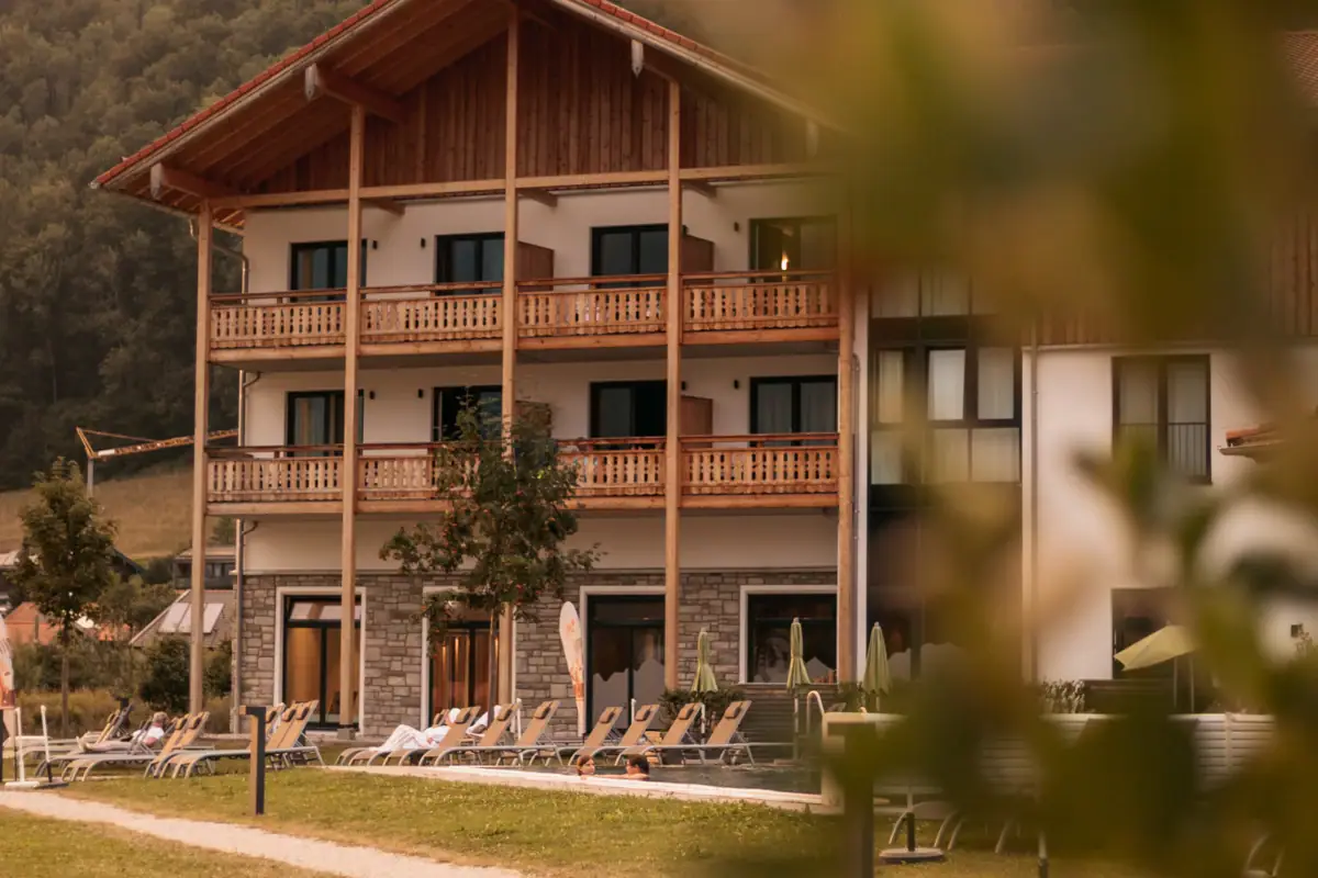 Ein Gebäude mit Rasenstühlen und Bäumen im Hintergrund.