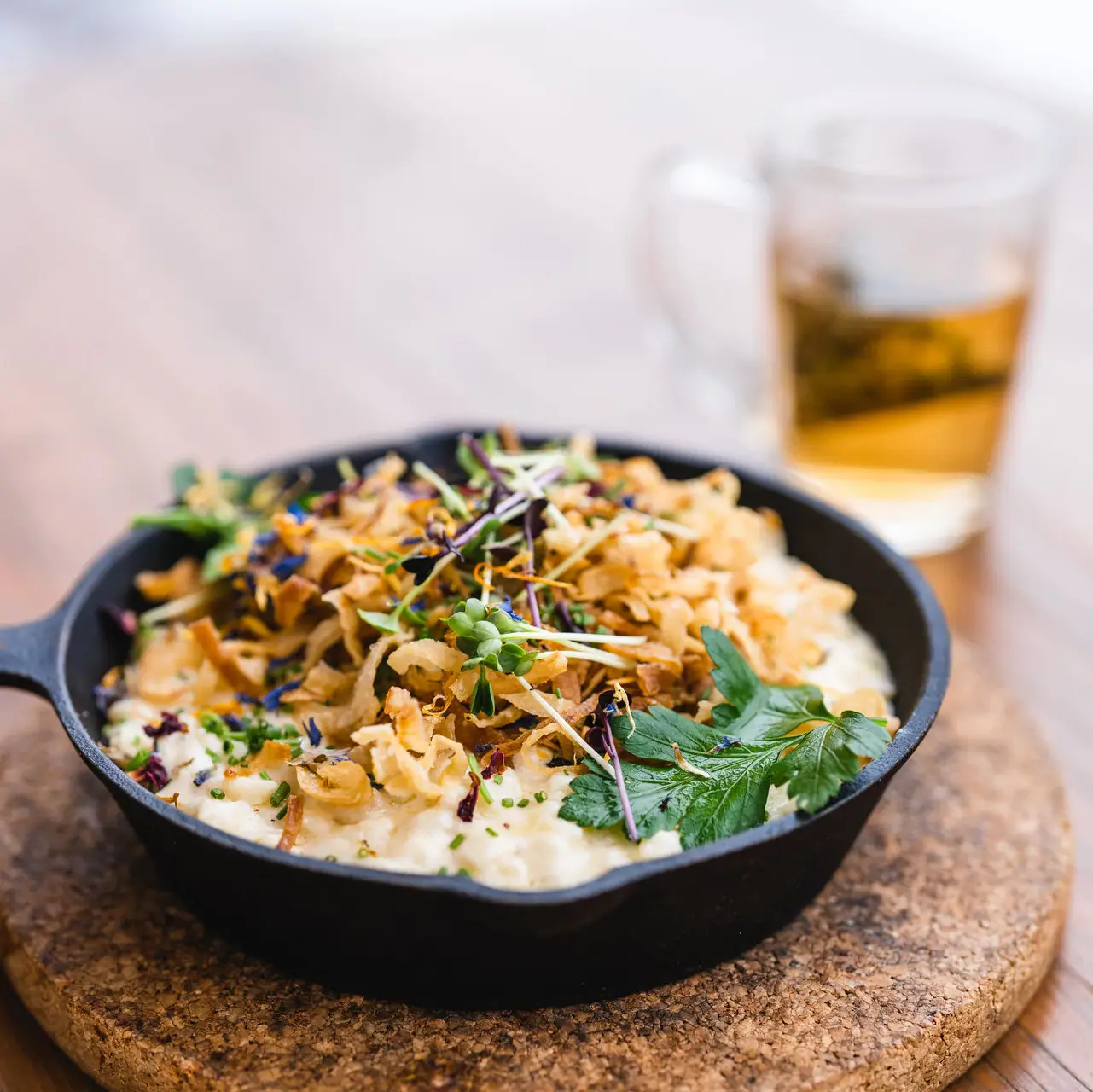 Käsespätzle Eine Pfanne mit Essen auf einem Tisch.
