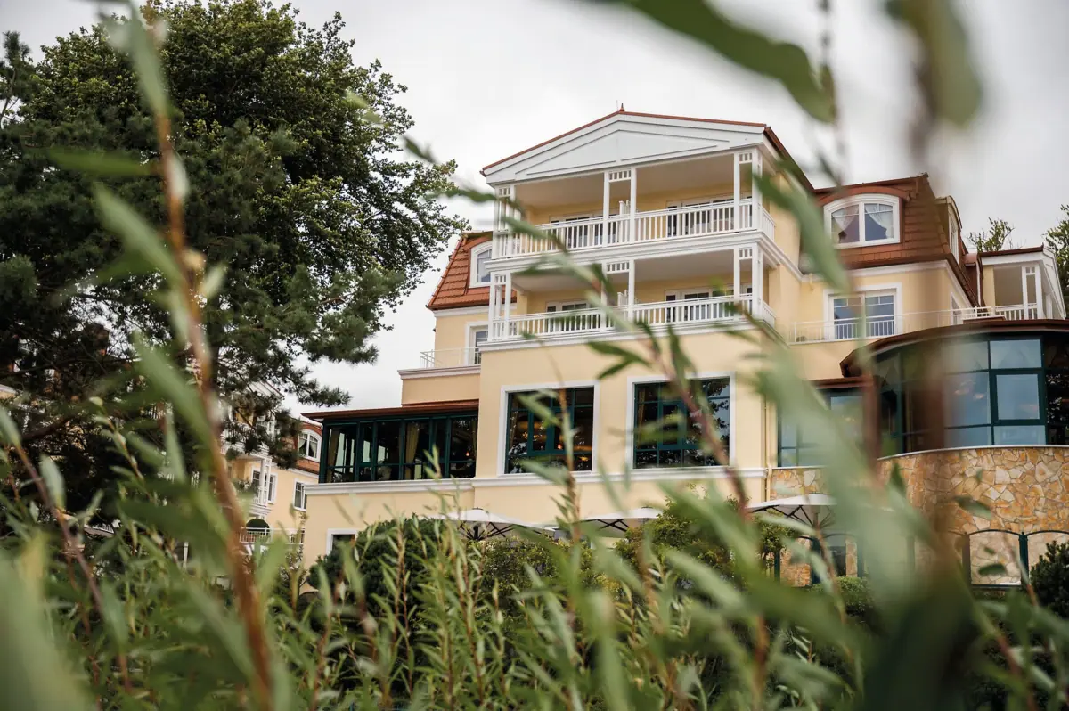 Ein Gebäude mit Fenstern und Bäumen im Hintergrund.