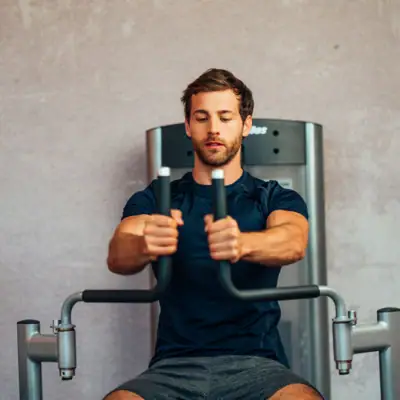 Ein Mann trainiert an einem Fitnessgerät.