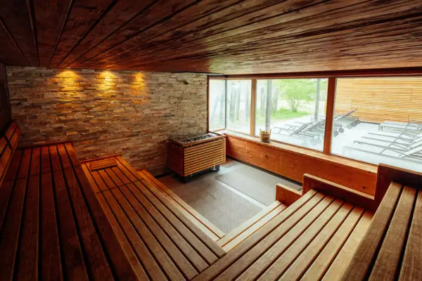 Finnische Sauna Ein Raum mit einer Holzbank und einer Steinwand.
