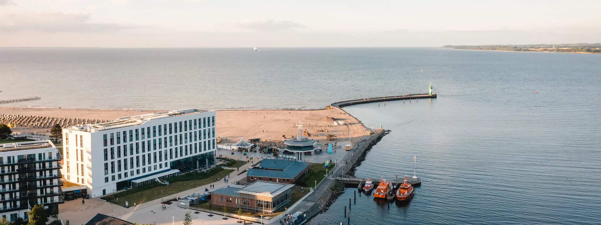 aja Travemünde Ein Gewässer mit Booten und Gebäuden.