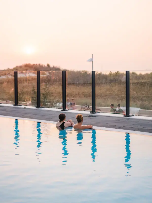 Zwei Personen schwimmen in einem Pool im Freien.