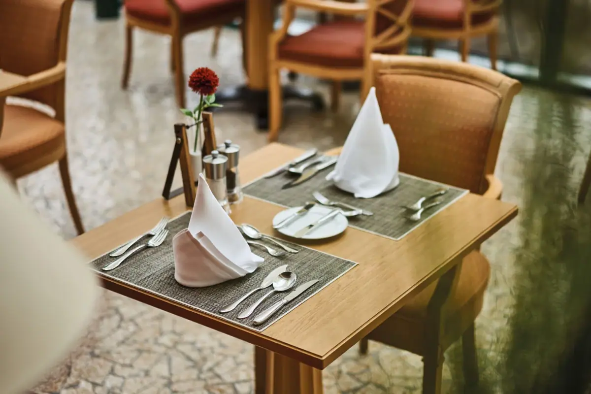 Tisch im Restaurant Ein Tisch mit Servietten und Besteck.