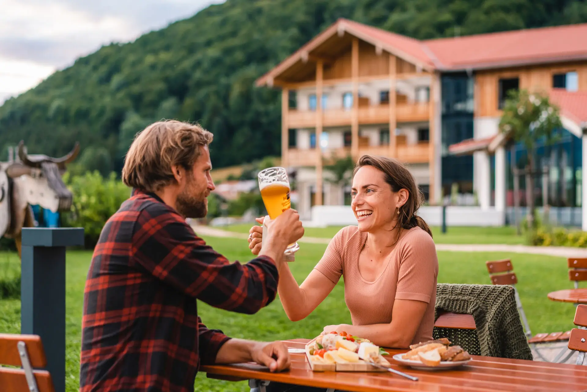 Biergarten Ruhpolding Ein Mann und eine Frau sitzen an einem Tisch mit Essen und Getränken.