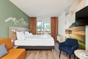 Doppelzimmer Bergblick mit Balkon aja Ruhpolding Ein Zimmer mit einem Bett und einem Stuhl.