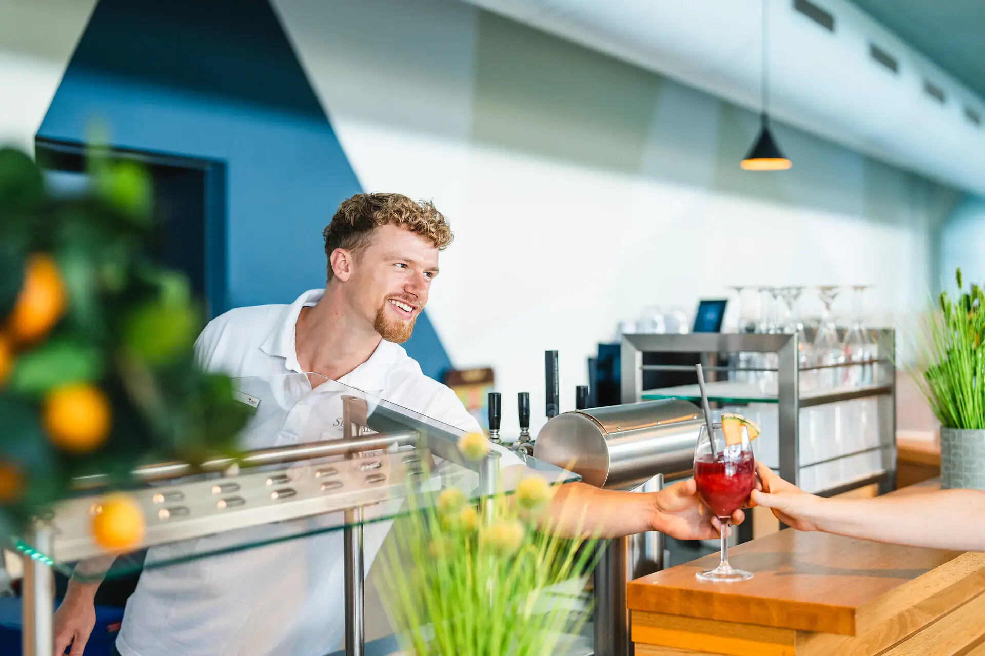 Ein Mann reicht einer Frau ein Getränk.