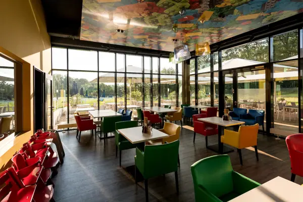 Ein Restaurant mit bunten Stühlen und Tischen.