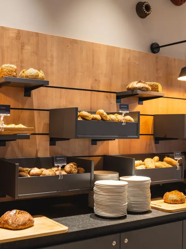 Auslage mit Brot und Tellern an einem Buffet