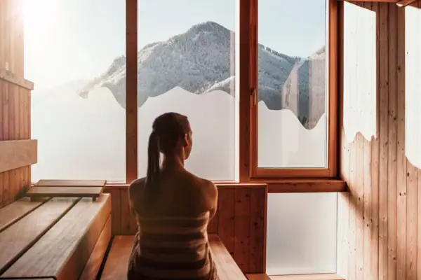 Eine Frau sitzt in einer Sauna.