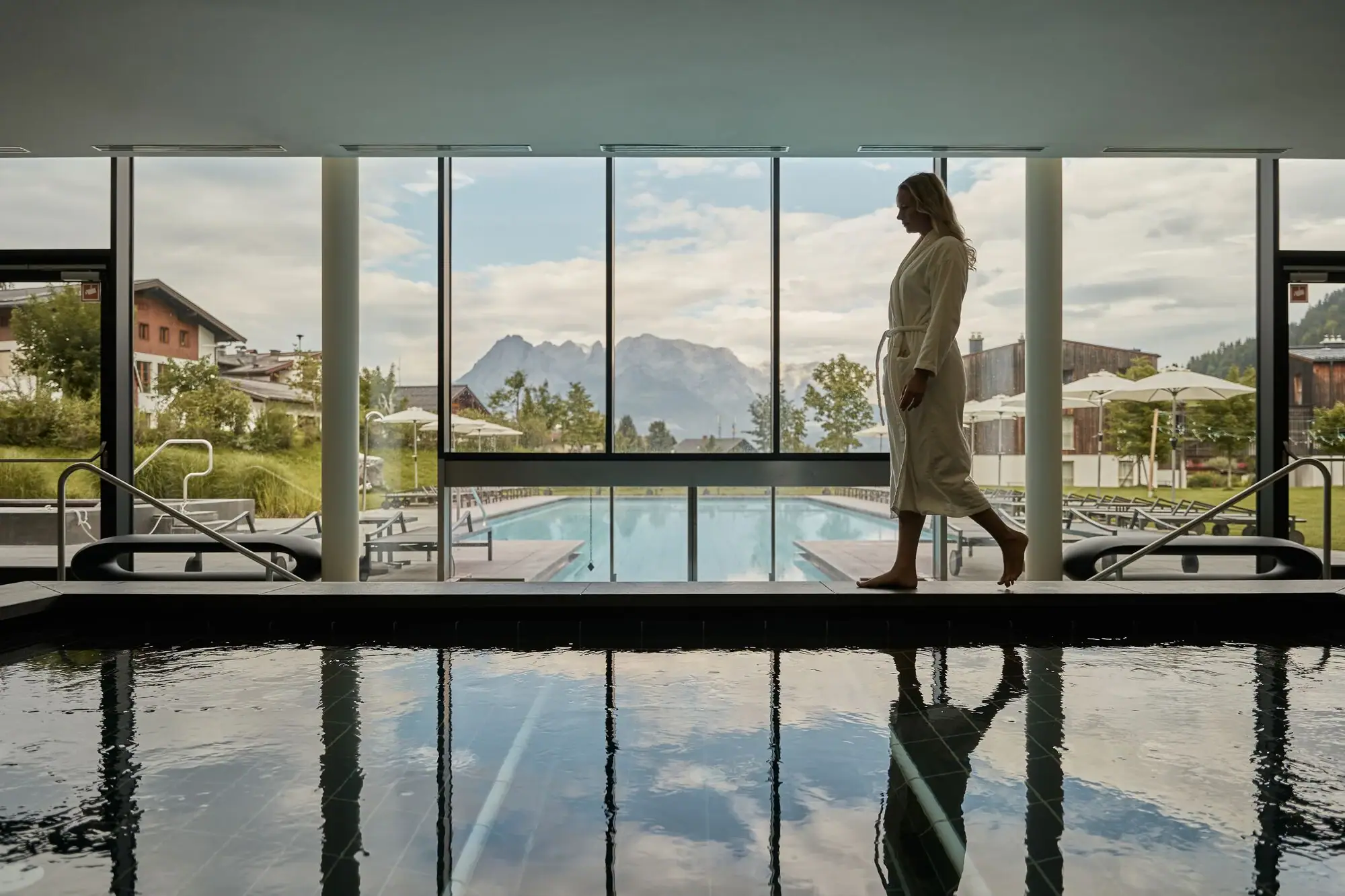 Eine Frau geht an einem Pool entlang.
