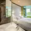 Ein Zimmer mit einer Dusche und einem Bett.