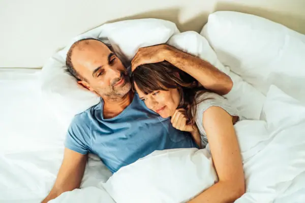 Ein Mann und eine Frau liegen im Bett.