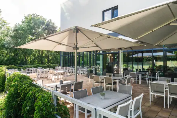 Eine Terrasse mit Tischen und Stühlen im Freien.