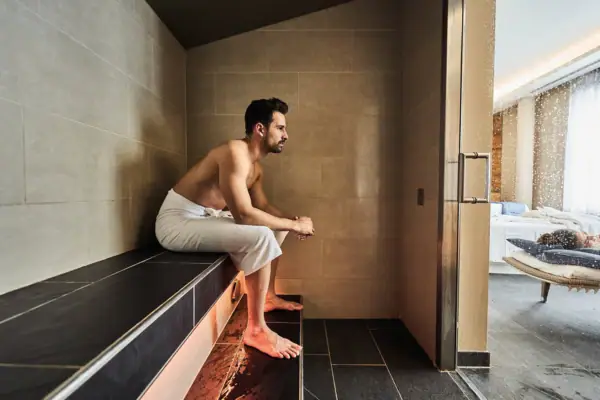Ein Mann sitzt auf einer Bank im Dampfbad