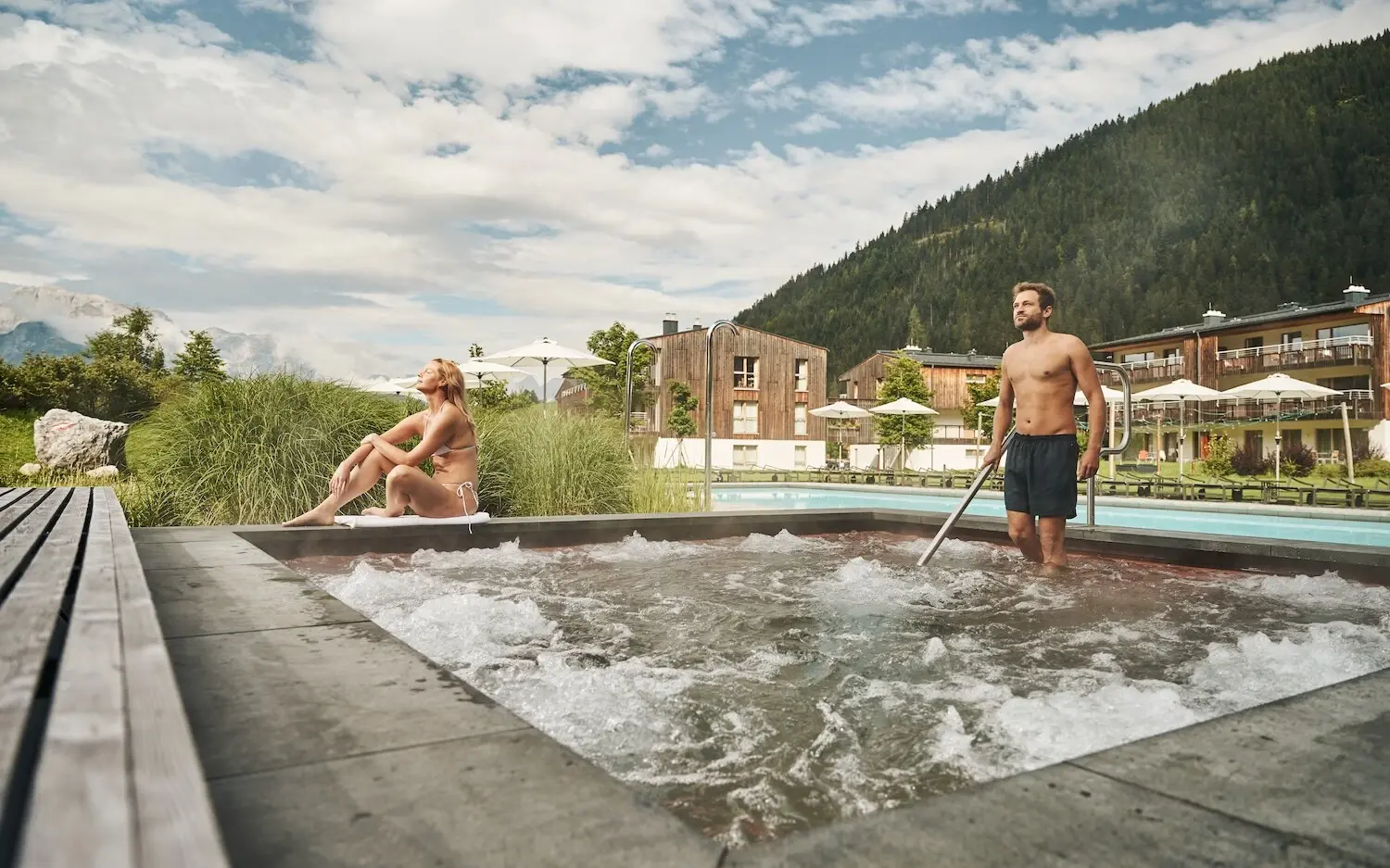 Ein Mann und eine Frau in einem Whirlpool im Freien.