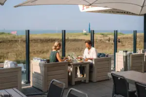 Eine Gruppe von Menschen sitzt an einem Tisch im Freien.