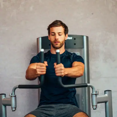 Ein Mann trainiert an einem Fitnessgerät.