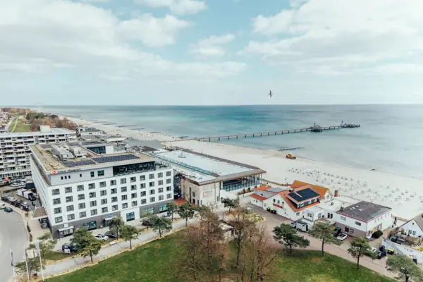aja Hotel Grömitz Strand mit Gebäuden und einem Pier im Vordergrund.