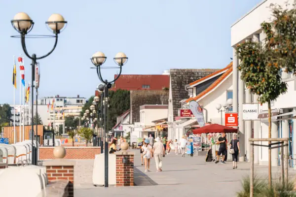 Eine Gruppe von Menschen, die auf einem Gehweg spazieren gehen.