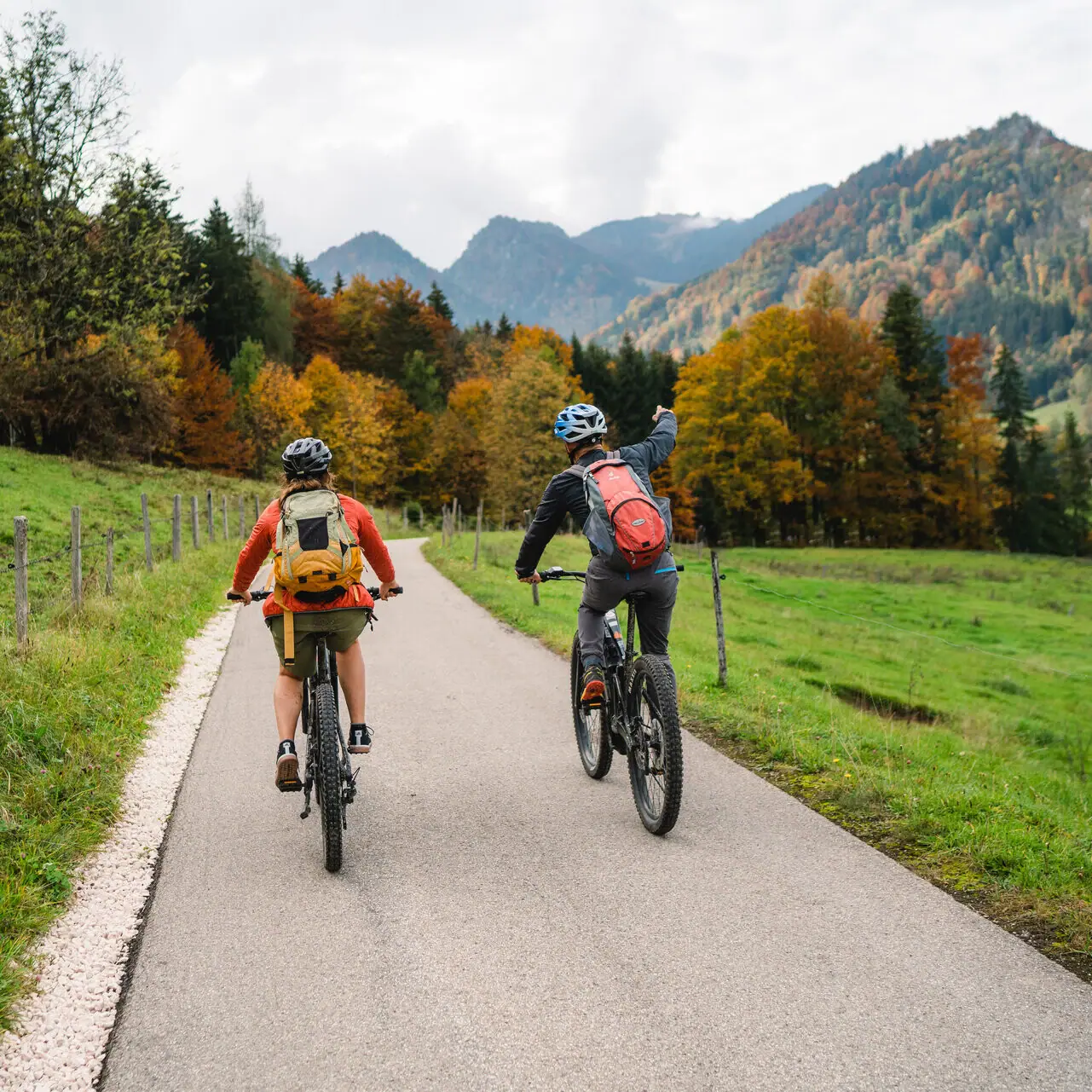 Zwei Personen fahren auf einer Straße in Ruhpolding im Chiemgau Fahrrad.