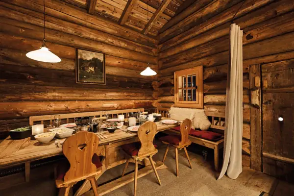 Ein Gastraum mit einem Tisch und Stühlen.