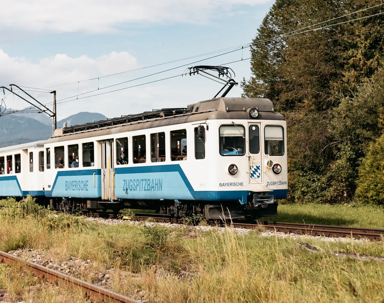 Die bayrische Zugspitzbahn auf Schienen unter freiem Himmel.