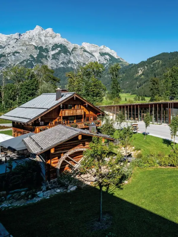 Ein Gebäude mit Glasdach und einer Straße, im Hintergrund Berge.