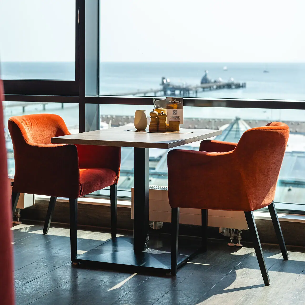Restaurant aja Grömitz Ein Tisch mit Stühlen und Blick auf das Meer.