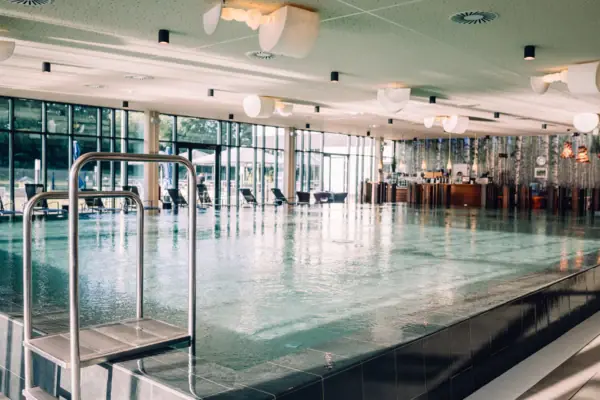 Großes Hallenschwimmbad mit klarem Wasser und moderner Architektur.