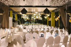 Saal Silvester Ein großer Saal mit vielen Tischen und Stühlen mit weißen Hussen.