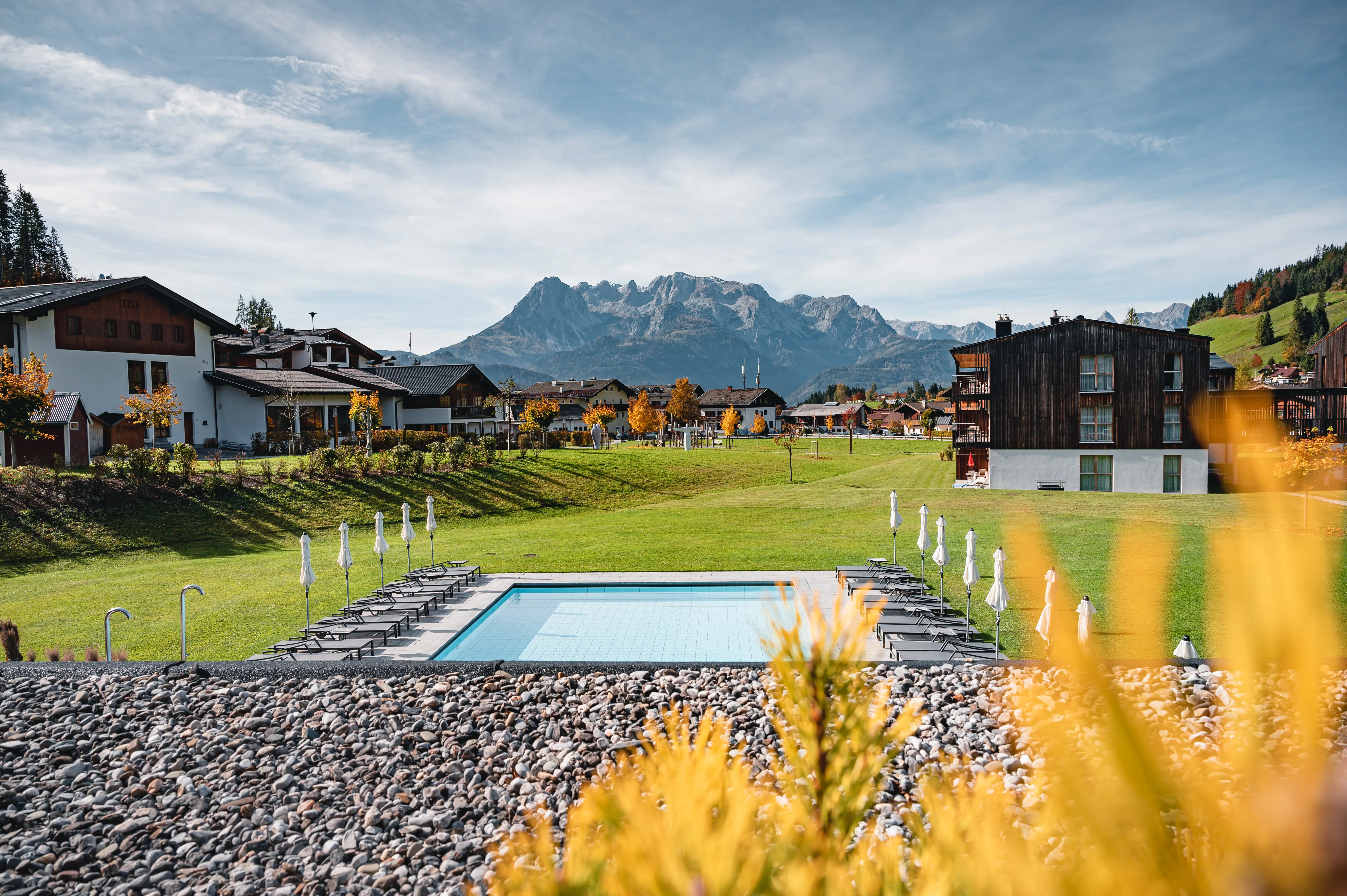 Ein Pool in einer grasbewachsenen Gegend mit Bergen im Hintergrund.