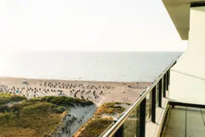 Zimmer im aja Warnemünde Ein Balkon mit Blick auf den Strand.