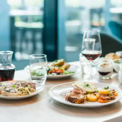 Ein Tisch mit Tellern voller Speisen und Weingläsern.